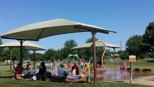 People seated under umbrellas in a park